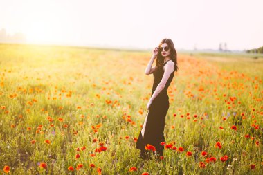 Gün batımında tarlada poz veren güzel bir kadın..