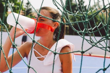 Genç bayan parkta topla oynuyor.