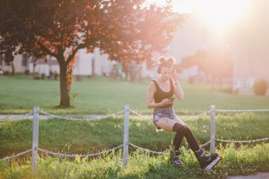 Spor kıyafetli genç bir kadın parkta selfie çekiyor.