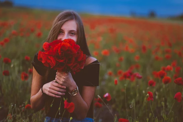 在罂粟地里穿着红衣服的漂亮姑娘 — 图库照片
