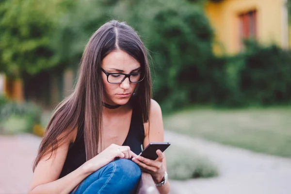 Jonge Vrouw Met Behulp Van Haar Smartphone Terwijl Zitten Bank — Stockfoto