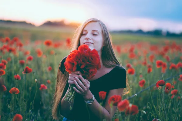 ポピーの花束で赤いドレスの美しい女の子 — ストック写真