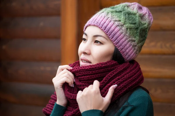 Beautiful brunette woman wearing knitted scarf and hat. — Stock Photo, Image
