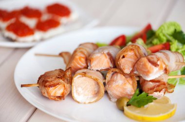 Pastırma dilimler halinde sarılmış kavrulmuş somon et parçaları