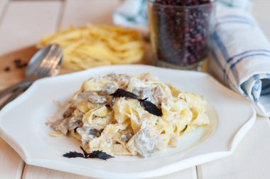 Fettuccine carbonara beyaz bir kase domuz eti ve mantar ile.