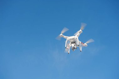 Parlak mavi gökyüzünde Quadrocopter insansız kamera uçuşu