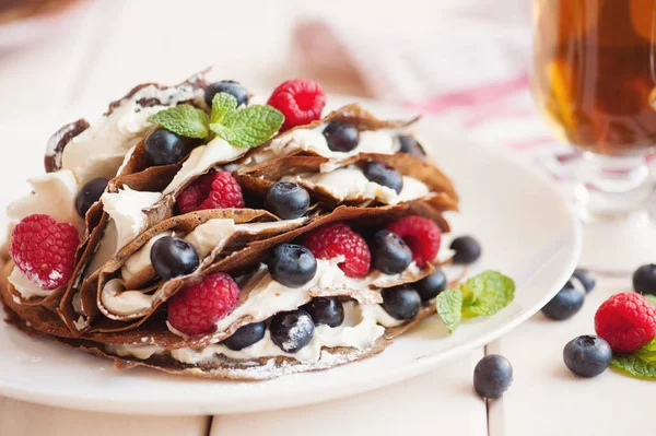 Pancakes with blueberries and raspberries, mascarpone cream and tea — Stock Photo, Image