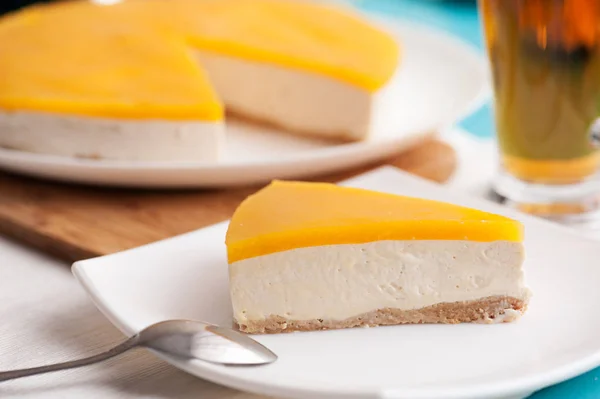 Mango cheesecake kaşık ile beyaz plaka üzerinde