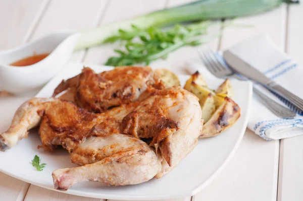 Roasted whole chicken on dish with cutlery