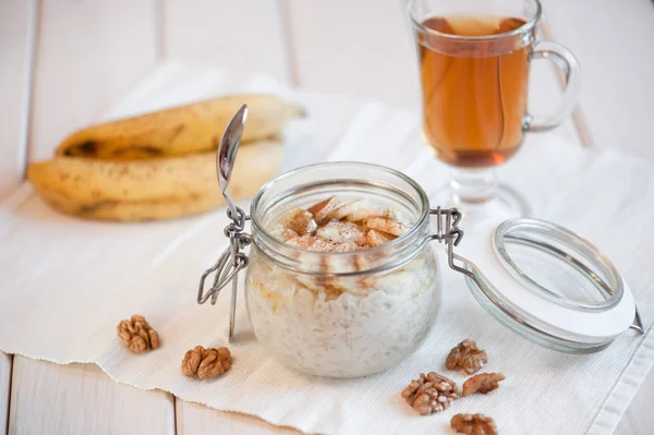 Oatmeal with banana and walnuts for breakfast — Stock Photo, Image