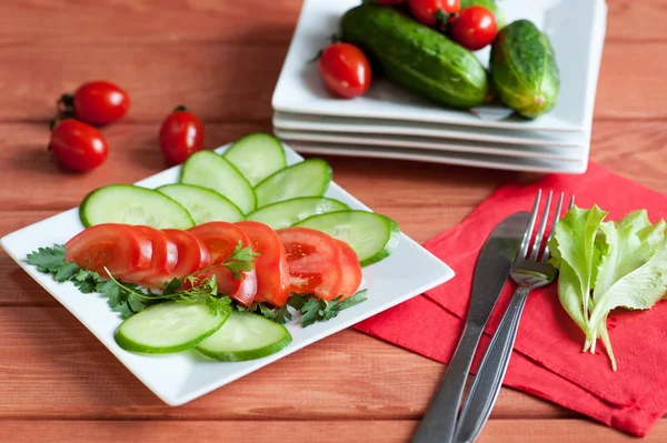 Dilimlenmiş domates ve salatalıklar bir tabakta yatıyor. — Stok fotoğraf