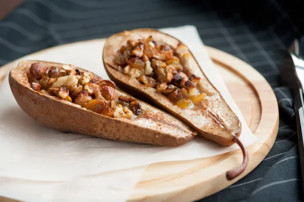 木製の板でナッツと蜂蜜焼き梨のデザート ストックフォト
