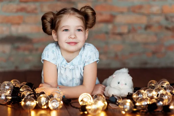 Little girl with bright christmas garland in her hand — Stock Photo, Image