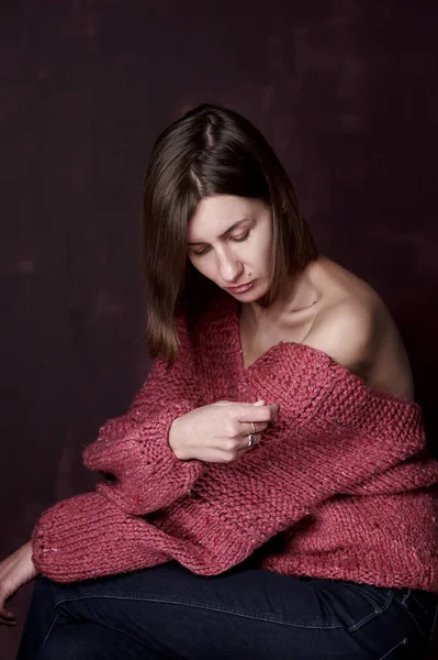 Retrato de una mujer en un suéter de punto cálido sobre un fondo oscuro — Foto de Stock
