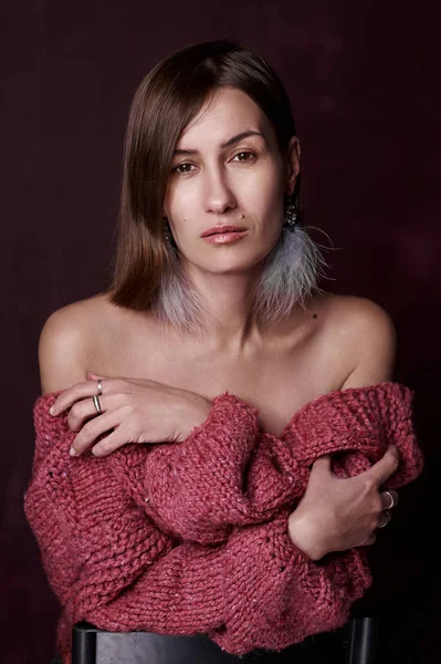 Portrait of a woman in a warm knitted sweater on a dark background — Stock Photo, Image