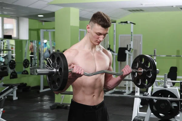 Le jeune homme s'entraîne au gymnase. — Photo