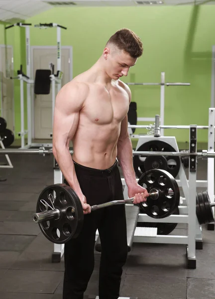 Le jeune homme s'entraîne au gymnase. — Photo