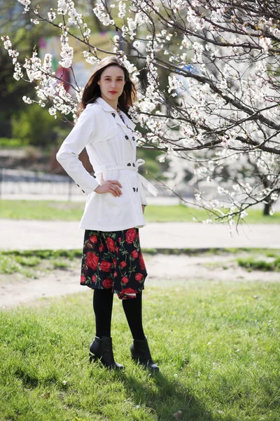 Retrato de una joven sobre un fondo de florecimiento abr —  Fotos de Stock