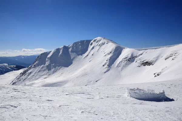 Parede de neve contra o fundo das montanhas — Fotografia de Stock