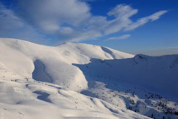 Mountai karla kaplı yamaçları üzerinde parlak mavi gökyüzü — Stok fotoğraf