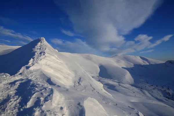 Jasny niebieski niebo nad pokryte śniegiem zbocza mountai — Zdjęcie stockowe