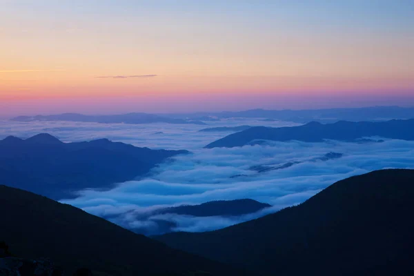 山の中で日の出 霧に覆われた谷の上に太陽が昇る — ストック写真