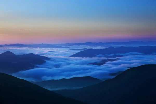 Sunrise in the mountains. The sun rises over the valleys covered with fog.