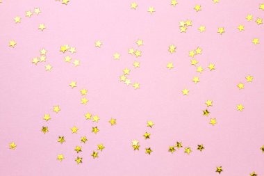 Altın parıltılı yıldızlı soyut pembe arkaplan.