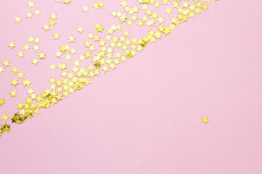 Altın parıltılı yıldızlı soyut pembe arkaplan.