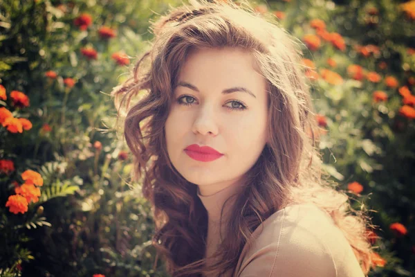 Mujer posa sobre fondo cama de flores —  Fotos de Stock