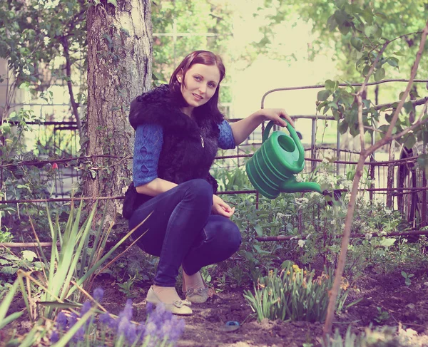 Fille dans les eaux de jardinage fleurs — Photo