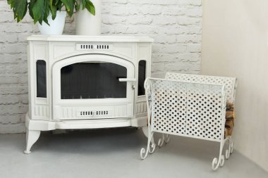 Odasında, ahşap beyaz renkte, metal işlemeli paleti olan yeni, güzel şömine.