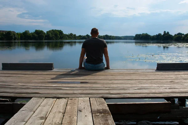Ahşap iskelede sıradan kıyafetleri olan bir çocuğun arka planı. Yaz günü. Özgürlük kavramı
