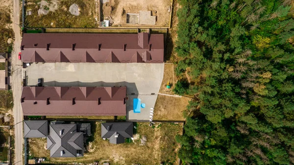 Çam ormanının yakınında yeni bir kasaba evi. Şehrin yakınındaki konforlu evler. İHA 'dan üst görünüm