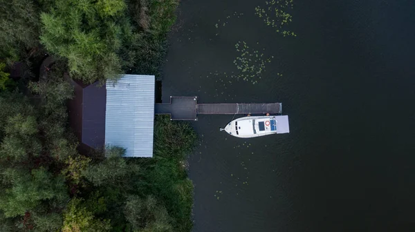Aerial birds eye view from drone of boat on the dark water near the berth, Ukraine