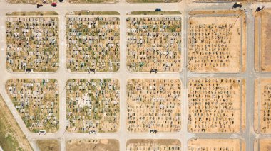 Mezar taşlarını ve mezar taşlarını gösteren hava fotoğrafı. Bazıları yaklaşan gün batımından kalma uzun gölgelerle dolu. Ukrayna, Avrupa