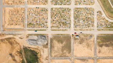 Mezar taşlarını ve mezar taşlarını gösteren hava fotoğrafı. Bazıları yaklaşan gün batımından kalma uzun gölgelerle dolu. Ukrayna, Avrupa