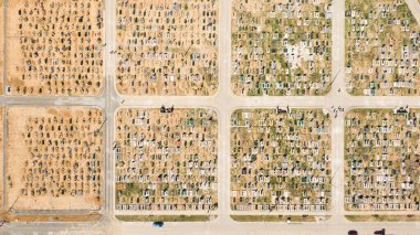 Mezar taşlarını ve mezar taşlarını gösteren hava fotoğrafı. Bazıları yaklaşan gün batımından kalma uzun gölgelerle dolu. Ukrayna, Avrupa