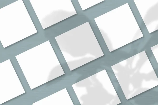 Kilka Kwadratowych Arkuszy Białego Papieru Teksturowanego Szarym Tle Ściany Makieta — Zdjęcie stockowe