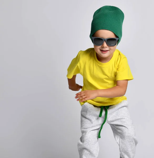 Vrolijk kind hipster jongen in een groene hoed dansen in brede broek — Stockfoto