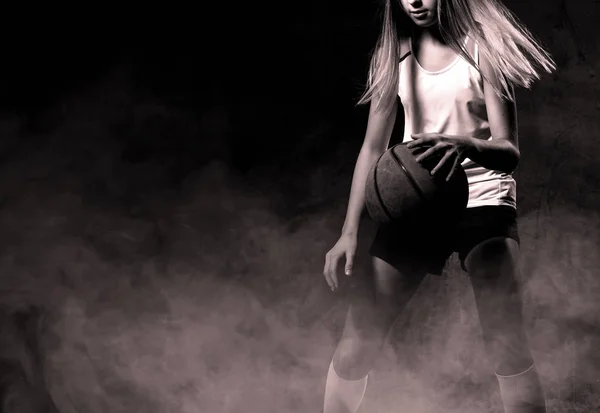 Schöne kaukasische Teenagerin in Sportbekleidung beim Basketballspielen. Sportkonzept isoliert auf schwarzem Hintergrund. — Stockfoto