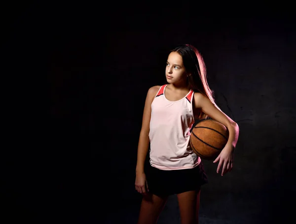Όμορφη καυκάσια έφηβη με αθλητικά να παίζει μπάσκετ. Αθλητισμός έννοια απομονώνονται σε μαύρο φόντο. — Φωτογραφία Αρχείου