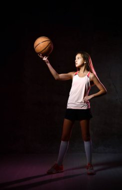 Spor giyim kuşağında basketbol oynayan güzel beyaz kadın. Spor kavramı siyah arkaplanda izole edildi.