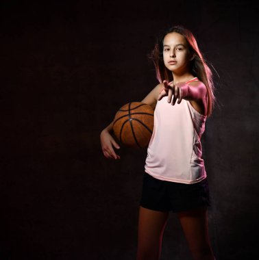 Spor giyim kuşağında basketbol oynayan güzel beyaz kadın. Spor kavramı siyah arkaplanda izole edildi.