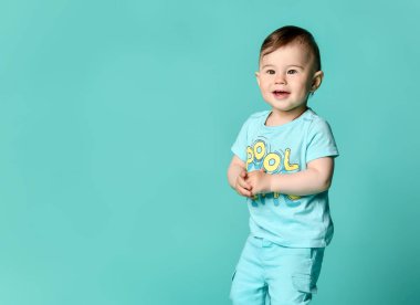 Turkuaz bir arka plan izole mavi bir yaz pamuk takım bir bebek çocuk tam uzunlukta portre.