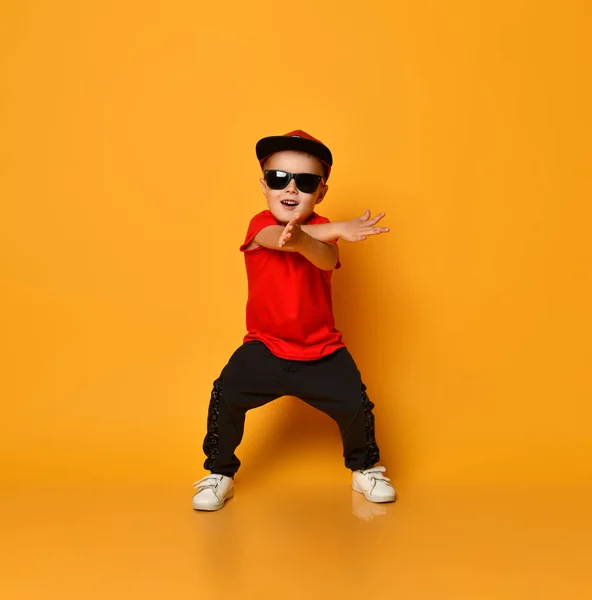 Щасливий маленький хлопчик танцює на жовтому тлі — стокове фото