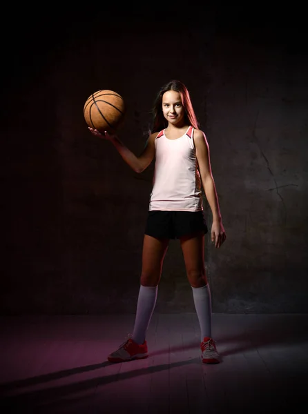 Hermosa mujer adolescente caucásica en ropa deportiva jugando baloncesto. Concepto deportivo aislado sobre fondo negro . — Foto de Stock