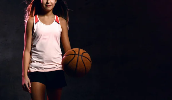 Hermosa mujer adolescente caucásica en ropa deportiva jugando baloncesto. Concepto deportivo aislado sobre fondo negro . — Foto de Stock