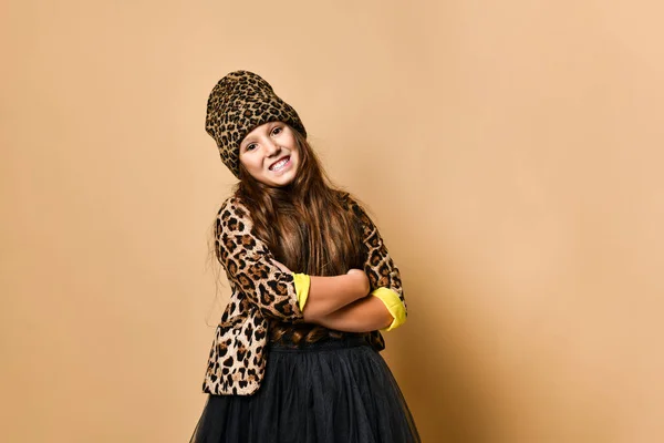 Genç ve cüsseli bir kız modeli şık bir leopar renginde günlük kıyafetler ve siyah etek ayakta ve gülümsüyor. — Stok fotoğraf