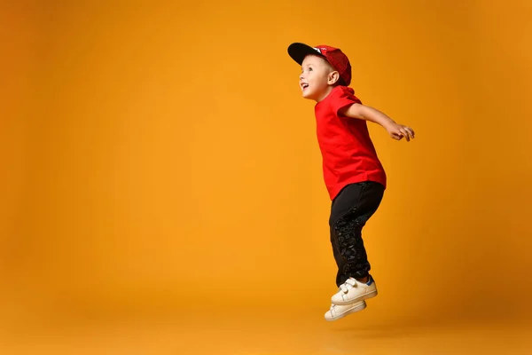 Küçük çocuk izole edilmiş sarı arka planda zıplıyor